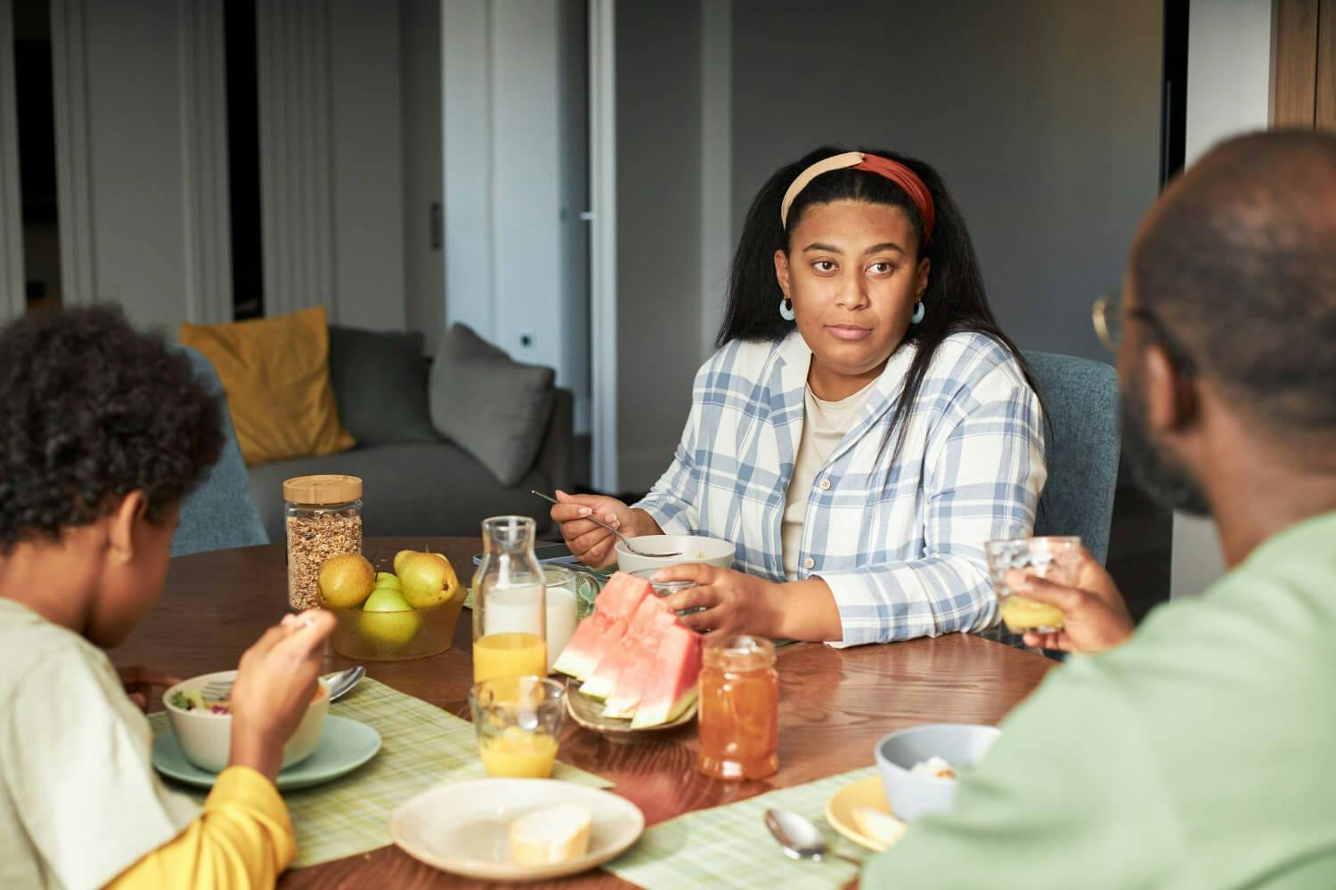 family sitting together at table to have a food - Help Someone with Eating Disorder