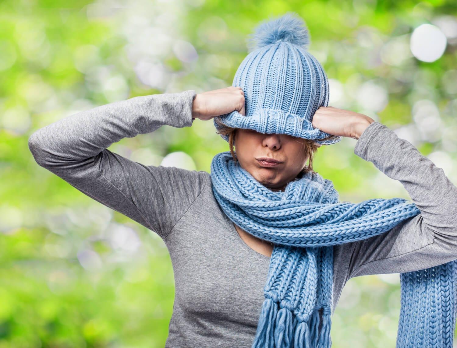  woman covering her eyes with knit cap due to shaking anxiety