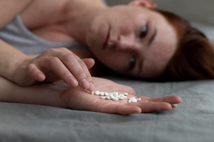 Close up depressed woman holding pills - Finding the Right Antidepressant Dose: Too Low or Too High[strong]