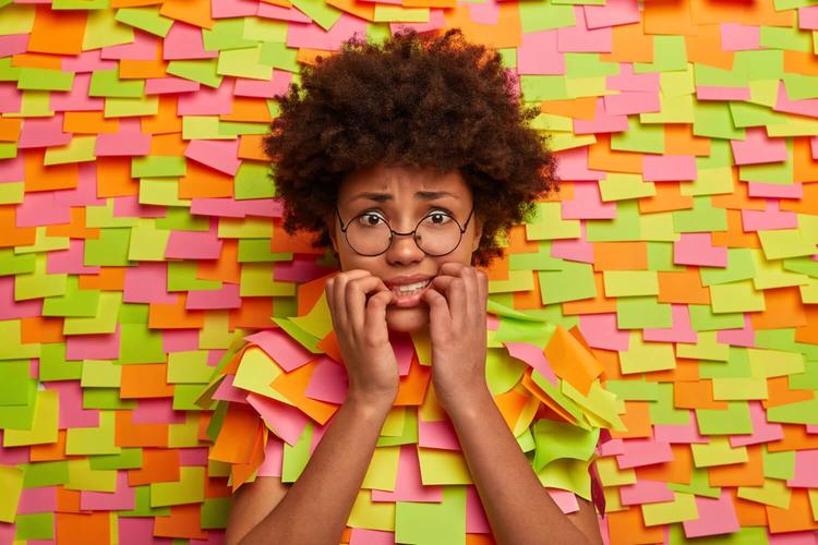 Close up on young student surrounded by sticky notes-Obsessive-Compulsive Disorder (OCD): Symptoms, Causes & Treatments